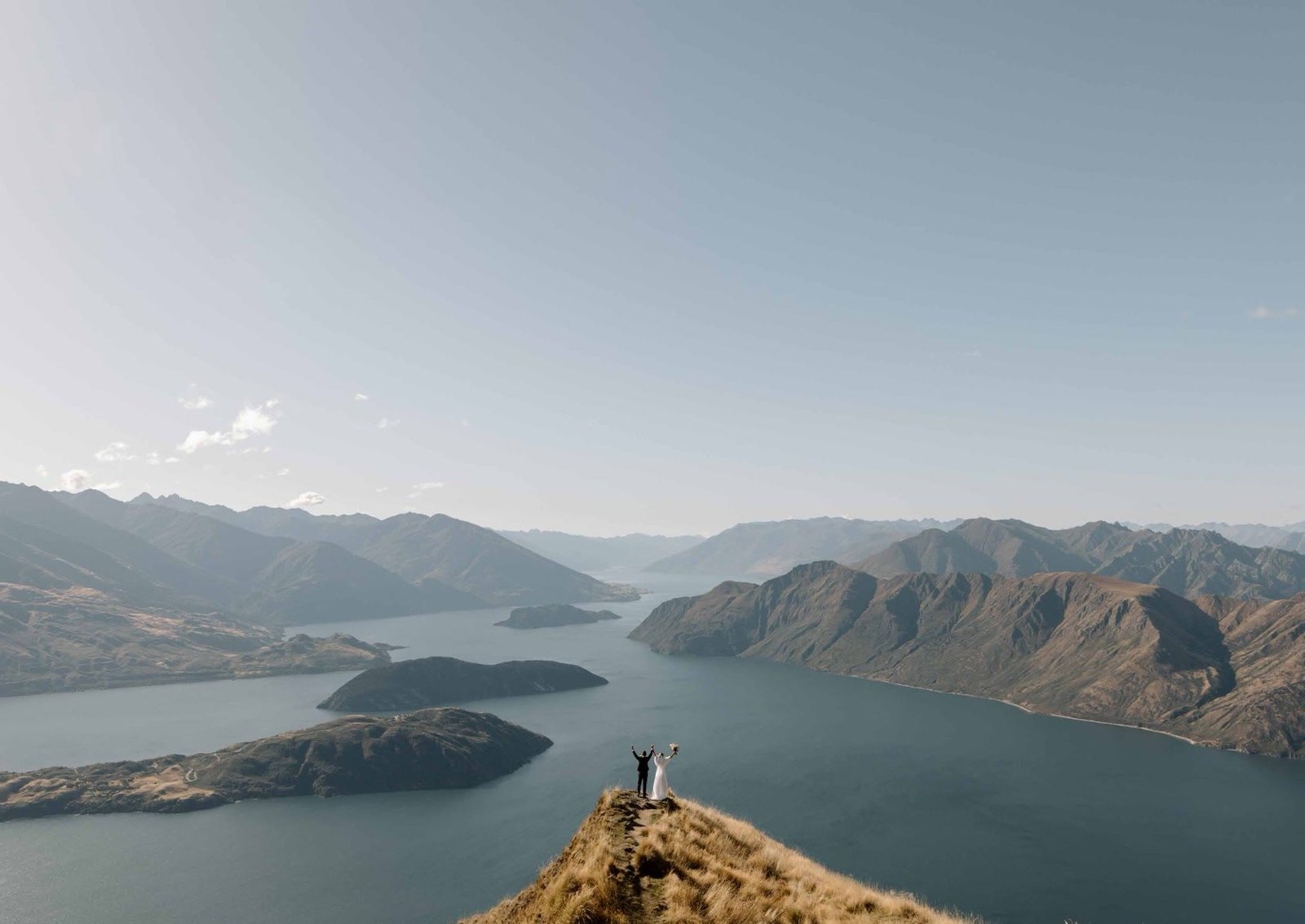 Un couple sur une crête, face aux lacs et aux montagnes de Nouvelle-Zélande